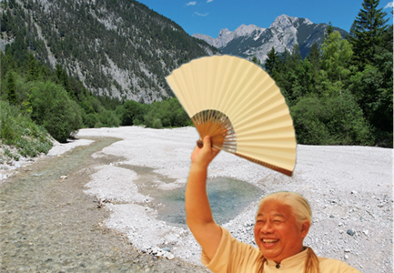 Ein fröhlicher Mann hält einen Fächer in einer malerischen Landschaft. Im Hintergrund sind schneebedeckte Berge und ein klarer Fluss zu sehen.