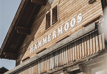 A traditional wooden house with the inscription "HAMMERMOOS". The facade features rustic details and a cozy atmosphere.