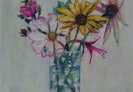 Een boeket van kleurrijke bloemen in een transparante vaas. De bloemen omvatten zonnebloemen, viooltjes en andere soorten.