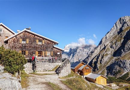 A picturesque mountain cabin surrounded by stunning rocks. The clear sky provides a wonderful backdrop.