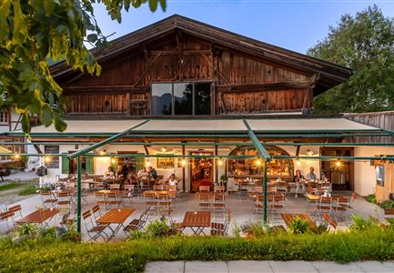 A cozy restaurant with an inviting terrace. The wooden construction and outdoor furniture create a warm atmosphere.