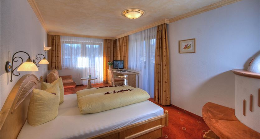 Ein gemütliches Hotelzimmer mit zwei Betten und weichen Kissen. Große Fenster lassen viel Tageslicht herein und sorgen für eine einladende Atmosphäre.