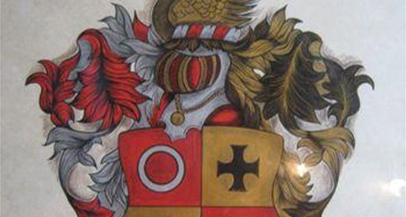 Ein Wappen mit farbenfrohen Motiven und zwei Löwen an den Seiten. Darunter steht der Name "Kruninger".