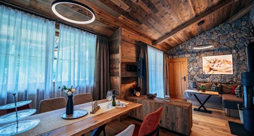 Un ambiente accogliente con pareti di legno e mobili moderni. Grandi finestre lasciano entrare molta luce e creano un'atmosfera invitante.