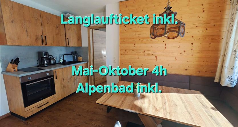 Eine moderne Küche mit Holzschränken und einem großen Esstisch. Es gibt einen angenehmen Essbereich mit viel natürlichem Licht.