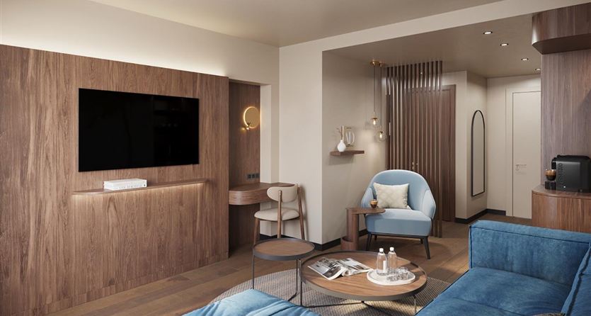 Un soggiorno moderno con un divano blu e una televisione sulla parete. L'arredamento è in legno e offre un'atmosfera accogliente.