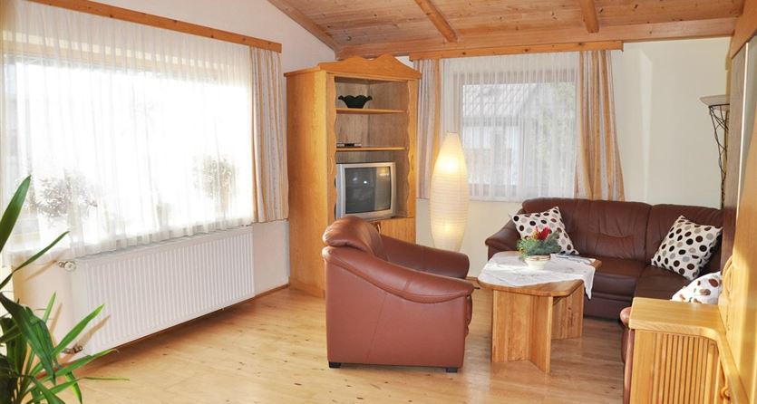 Gemütliches Wohnzimmer mit Zugang zum Balkon – Südwest-Ausrichtung

Das helle und einladende Wohnzimmer unserer Ferienwohnung bietet Ihnen eine behagliche Atmosphäre zum Entspannen. Ausgestattet mit einer bequemen Couchgarnitur, SAT-TV und liebevollen Details, lädt der Raum zum Verweilen ein. Die großen Fenster und die Terrassentür – mit direktem Zugang zum Balkon – sorgen für viel Tageslicht und bieten einen herrlichen Blick in Richtung Südwesten. Genießen Sie sonnige Nachmittage und stimmungsv