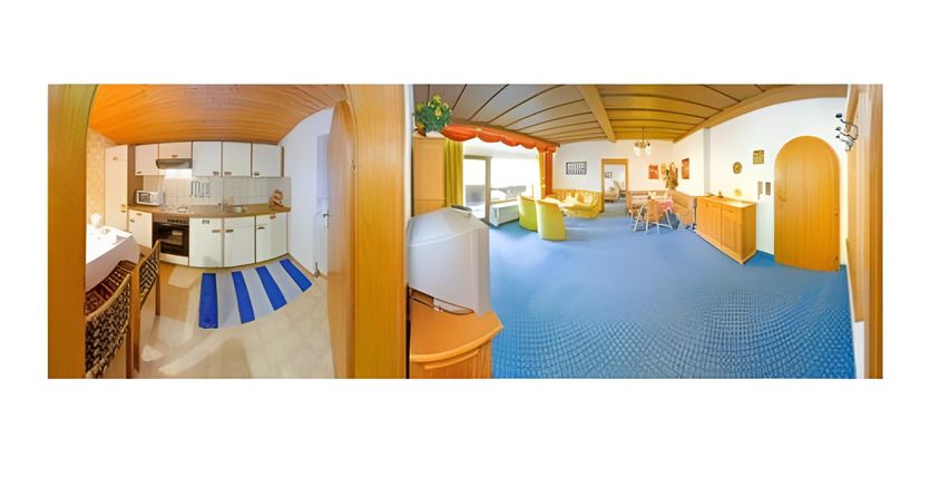 Eine helle und einladende Wohnung mit einer modernen Küche und einem gemütlichen Wohnbereich. Der Raum ist mit Teppichboden ausgelegt und wirkt freundlich und geräumig.