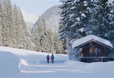 Winter hiking by a snow-covered hut