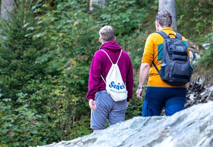 Einhornmarsch-Teilnehmer mit Seefeld-Beutel laufen an der Leutascher Ache entlang.jpg