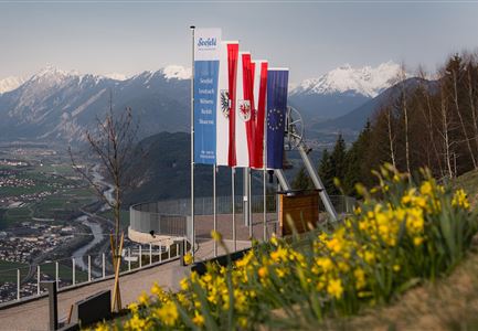 Friedensglocke im Frühling - Blick auf Fahnen mit Blumen.jpg