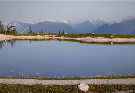 Gschwandtkopf Speichersee - Trailrunner in der Distanz läuft entlang des Sees bei Sonnenaufgangsstimmung.jpg