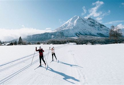 Langlaufen in der Region Seefeld_zwei Langläufer auf C9 Plaik Loipe in Leutasch_Weitwinkelaufnahme mit Hohe Munde.jpg