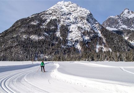 Loipe A8 Lehner mit Langlaeuferin und Blick auf Gehrenspitze und Oefelekopf im Wetterstein