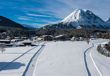 Luftaufnahme der Loipe A10 Weidach und Winterwanderweg mit Langlaeuferin und Hoher Munde