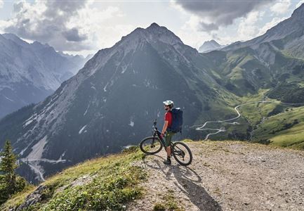 Radfahrer bei der Auffahrt zur Rotmoosalm - Pause mit Blick auf die Berge