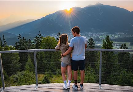 Sonnenaufgang Aussichtsplattform Bruschkopf - Paar steht am Geländer der Plattform - Aufnahme von hinten - Paar schaut sich an.jpg