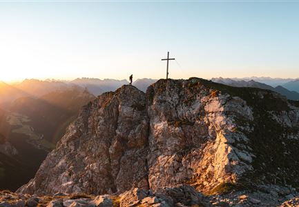 Wanderer auf der Gehrenspitze ueber Leutasch im Sonnenaufgang - Panoramaaufnahme.jpg